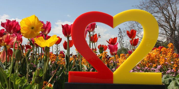 Logo des Deutschen Einheitsfestes 2022 vor Blumen
