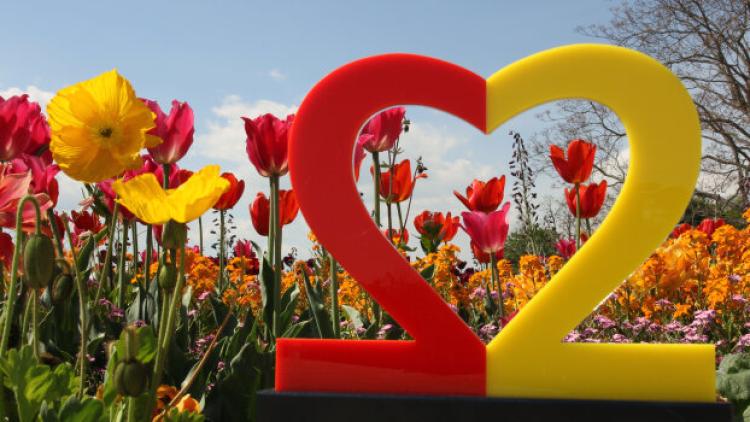 Logo des Deutschen Einheitsfestes 2022 vor Blumen